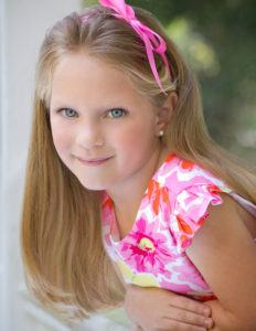 Pretty blonde girl smiling leaning on a railing